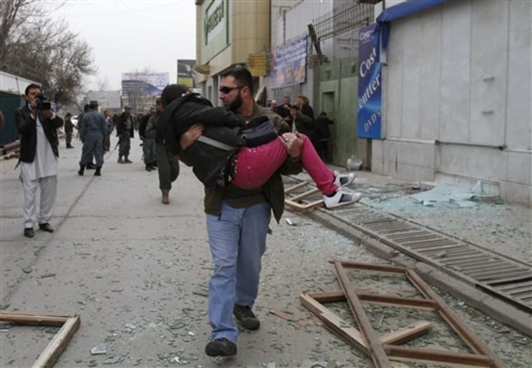 An injured woman is carried out of a supermarket in Kabul, Afghanistan, after a bombing on Friday.